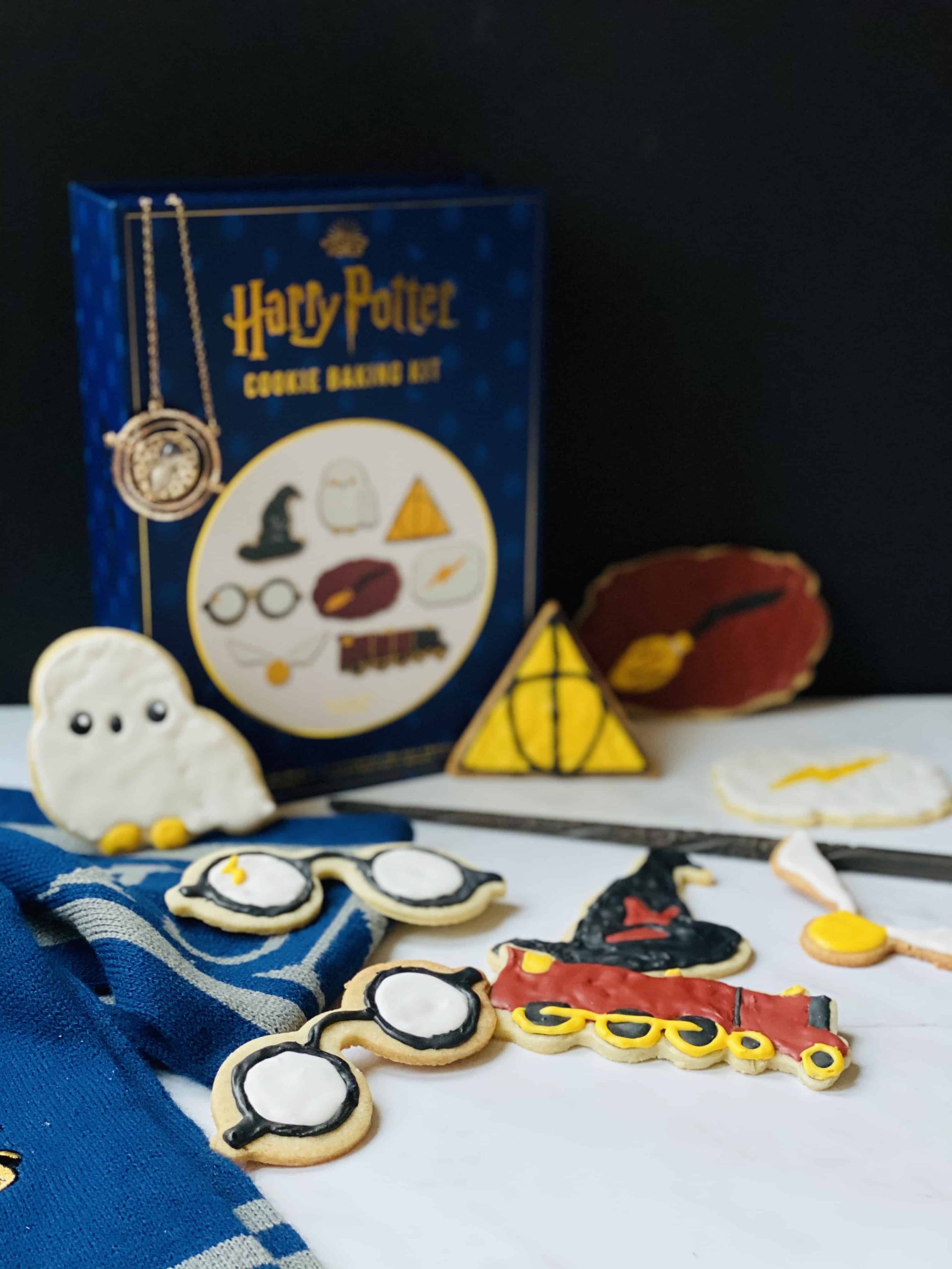 Sugar cookies with a Harry Potter baking kit box on a marble surface.