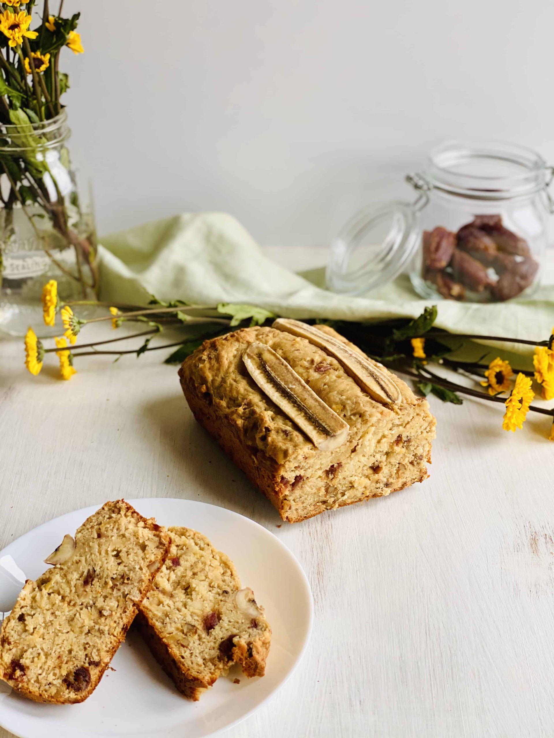 A sliced loaf of banana bread on a small plate.