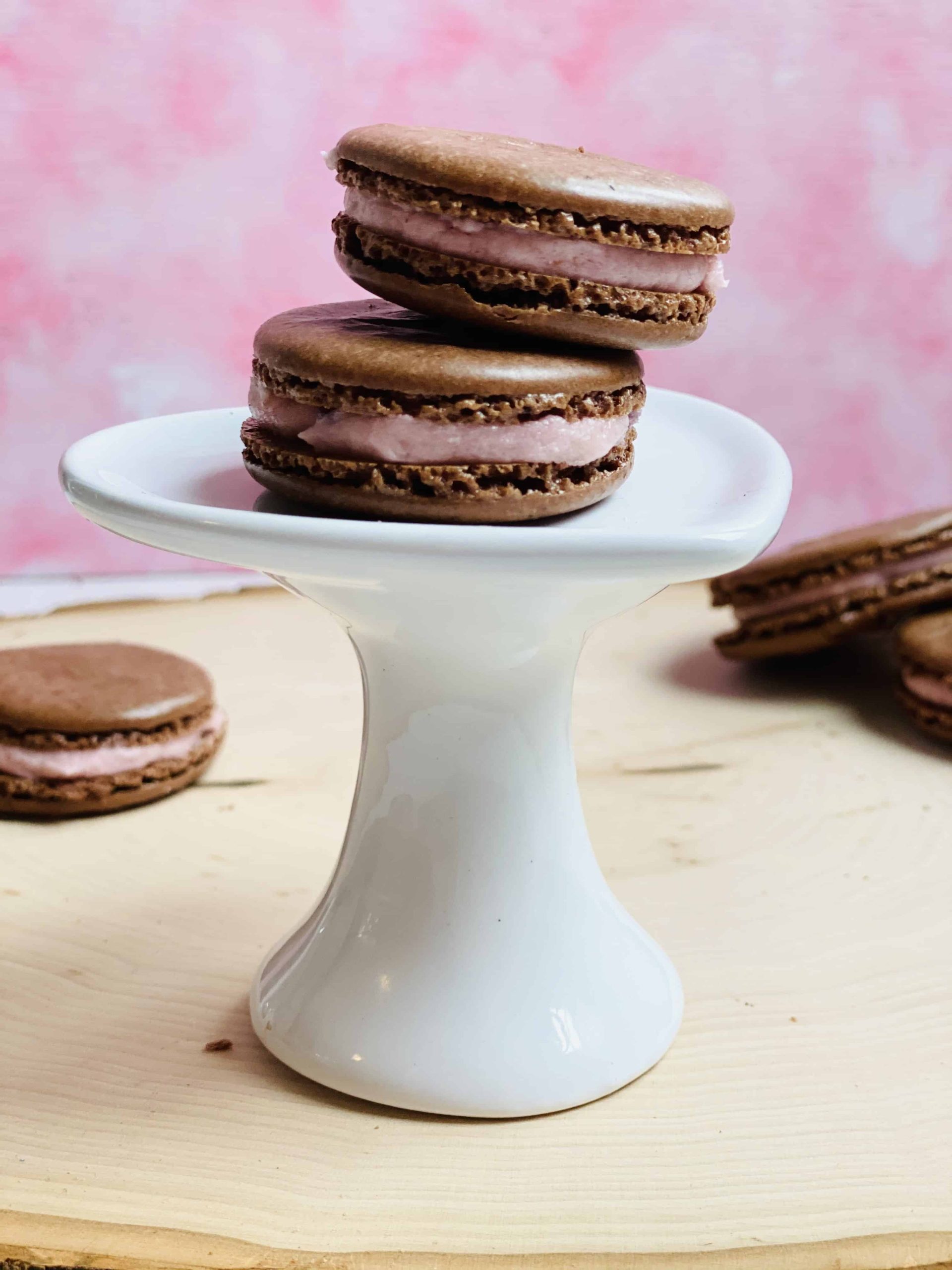 Two macarons on a tiny cupcake stand.