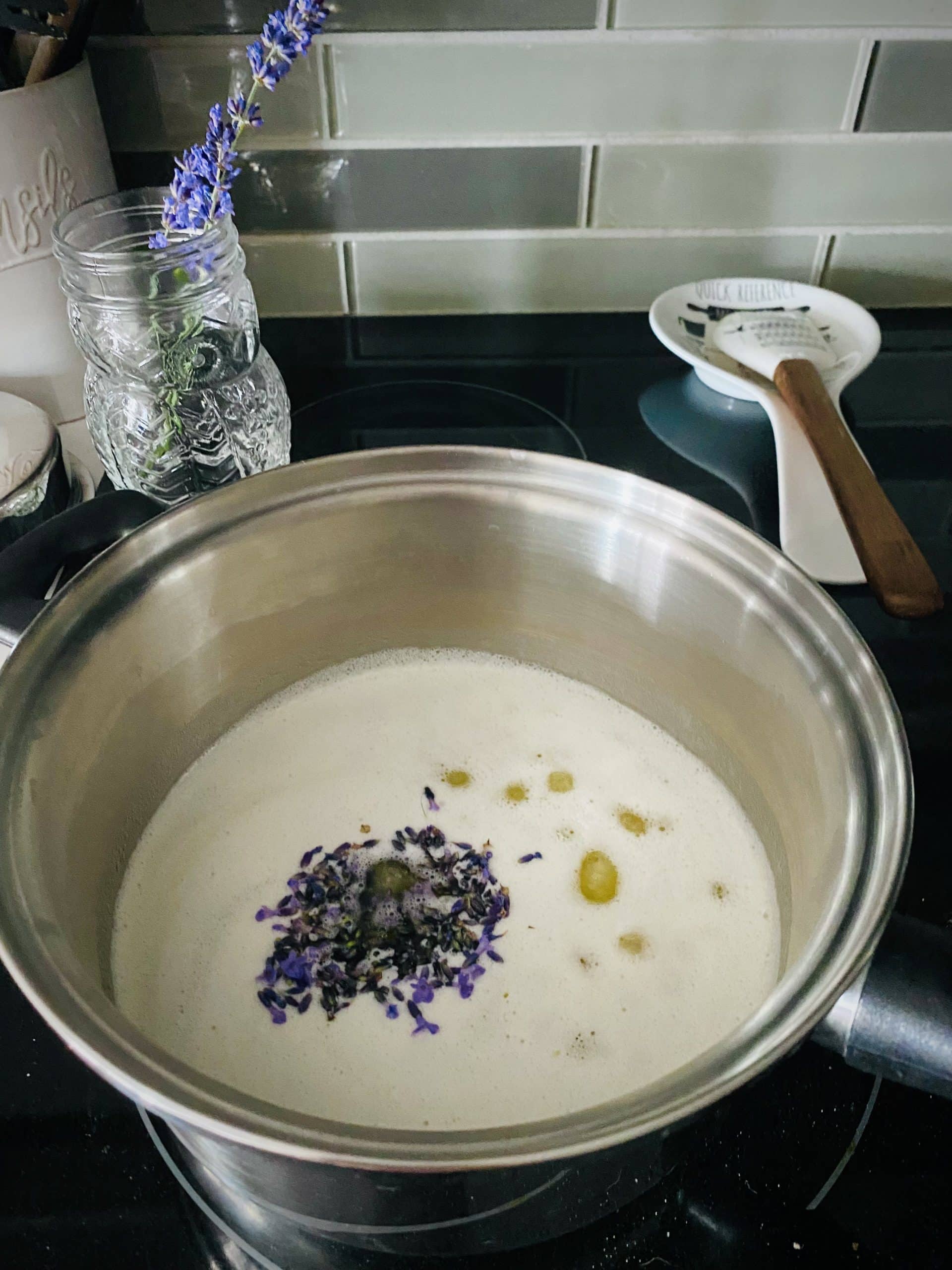 Mleted butter simmering in a pot with lavender buds being infused into it.