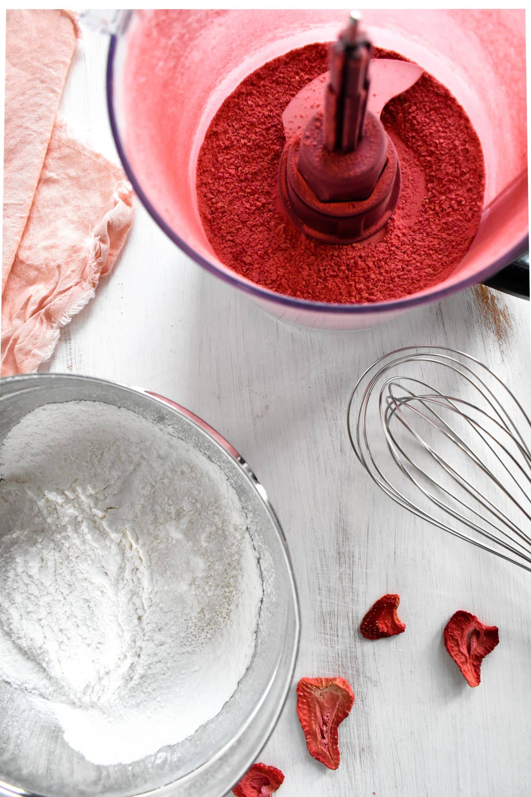 A food processor full of pink powdered freeze dried strawberries.