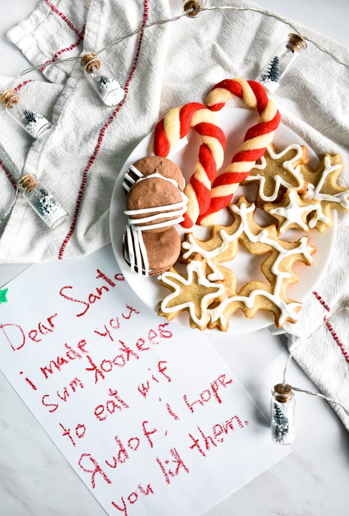 Christmas cookies laid out on a plate with a letter for Santa written in crayon