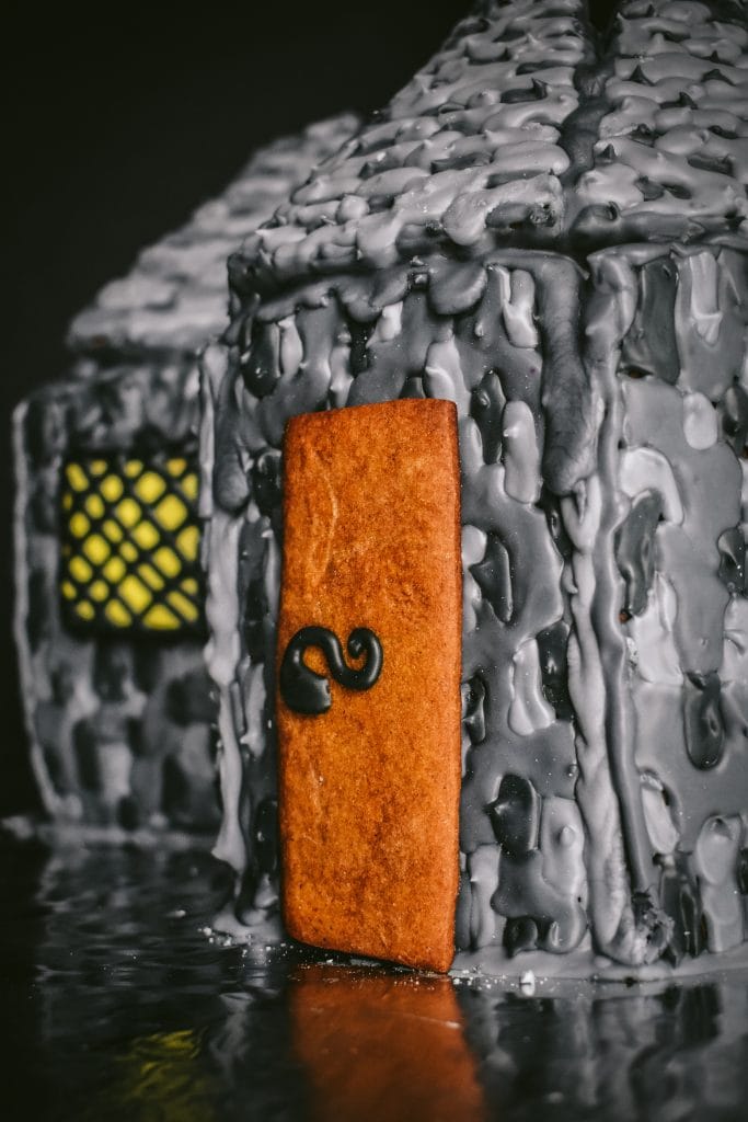 side view of a DIY gingerbread door and window on stone walls on a DIY gingerbread house
