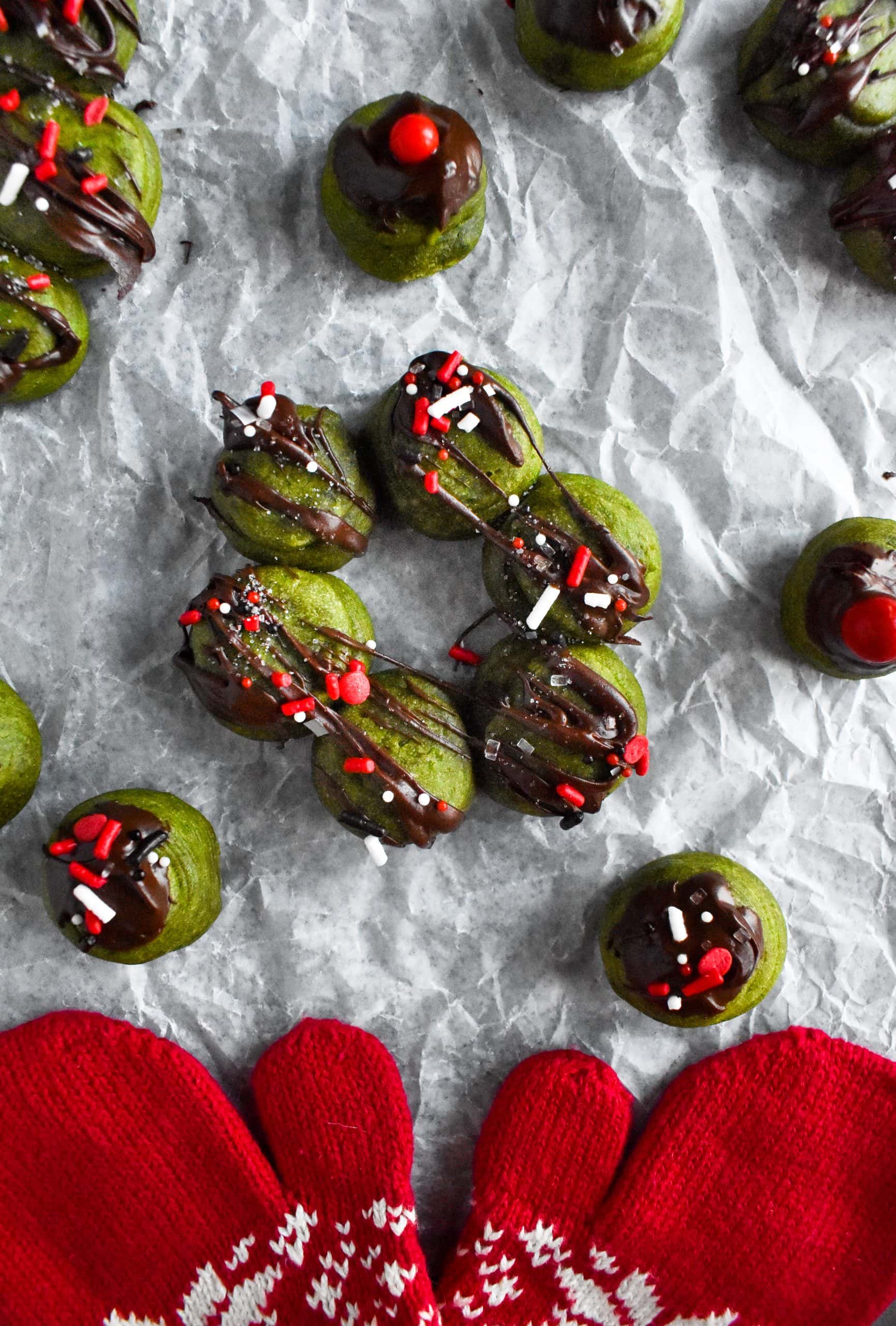 A baked green mochi donuts laid out on a sheet of crinkled wax paper. 