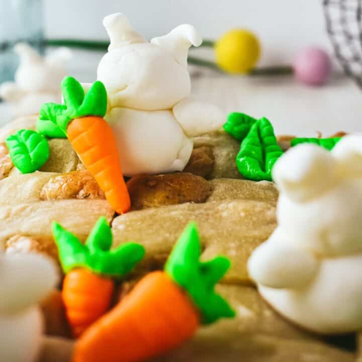 Baked bread buns topped with fondant bunnies, carrots, and leaves.