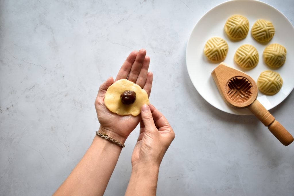two hands forming Maamoul (Mamool) - Date Cookies