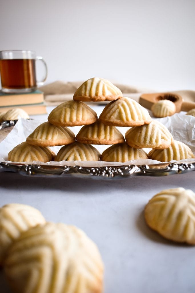 pyramid of two hands forming Maamoul (Mamool) - Date Cookies on a silver serving tray
