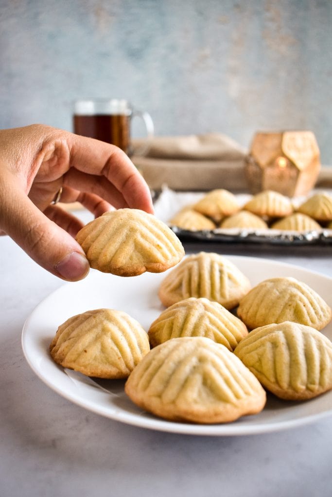 a hand reaching in to pick up a middle eastern cookie