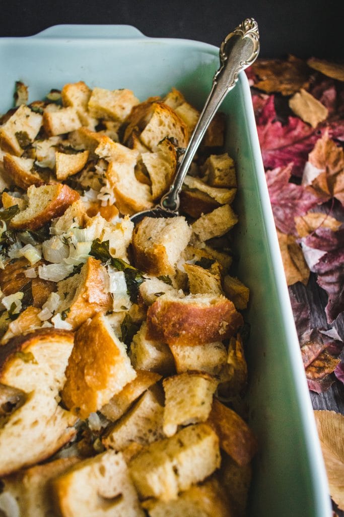 metal spoon scooping Sourdough Stuffing from a blue dish