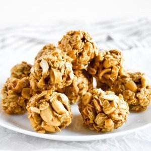 A stack of a dozen peanut and oatmeal energy balls on a white plate.