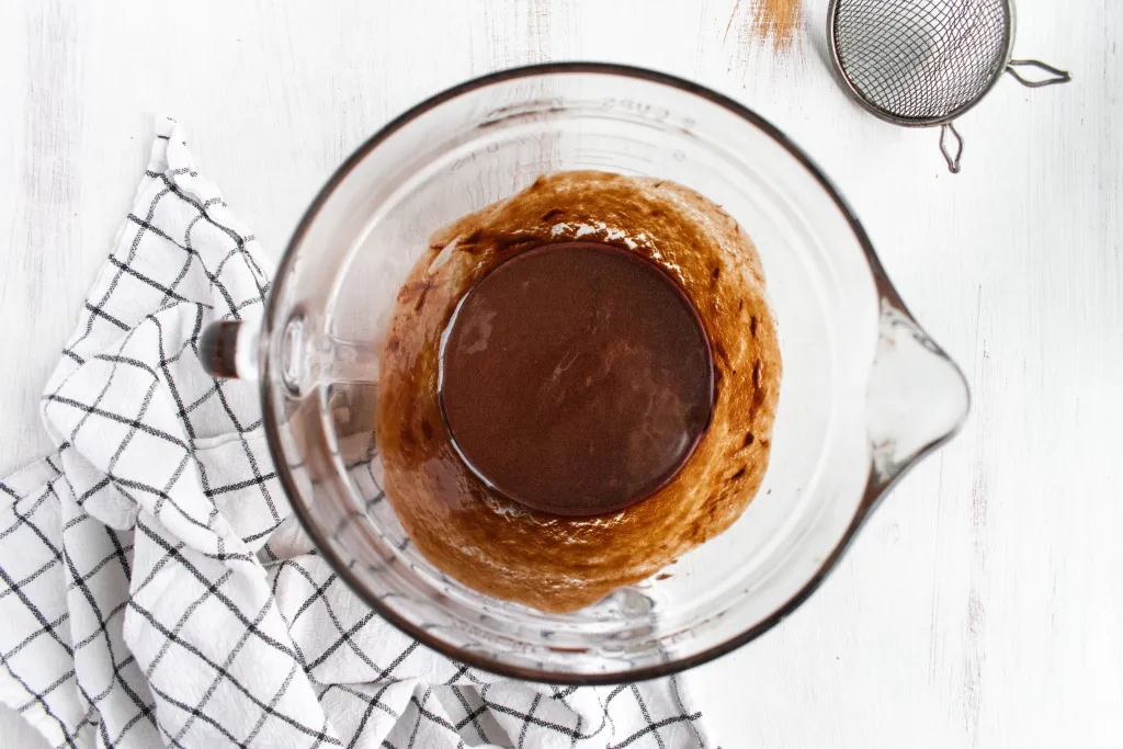 Melted chocolate, vegetable oil, and an egg mixed in a mixing bowl.