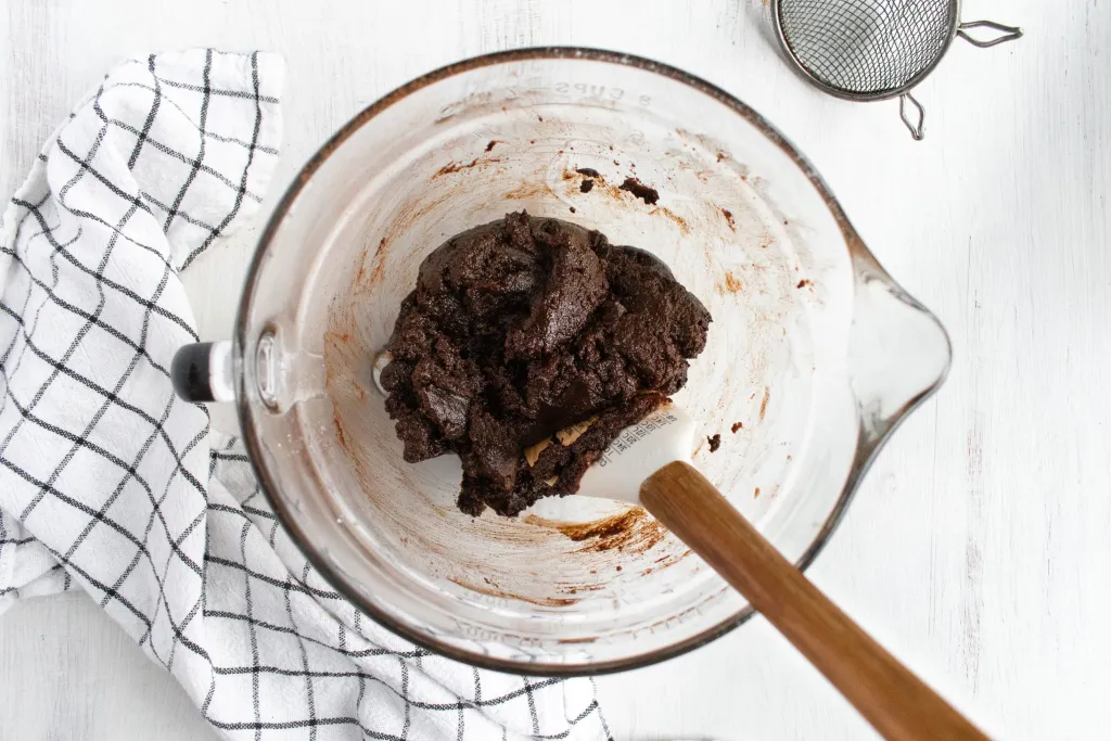Thick, dark batter in a mixing bowl with a spatula.