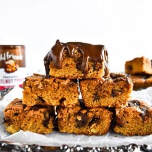 Six blondies stacked on a serving platter.