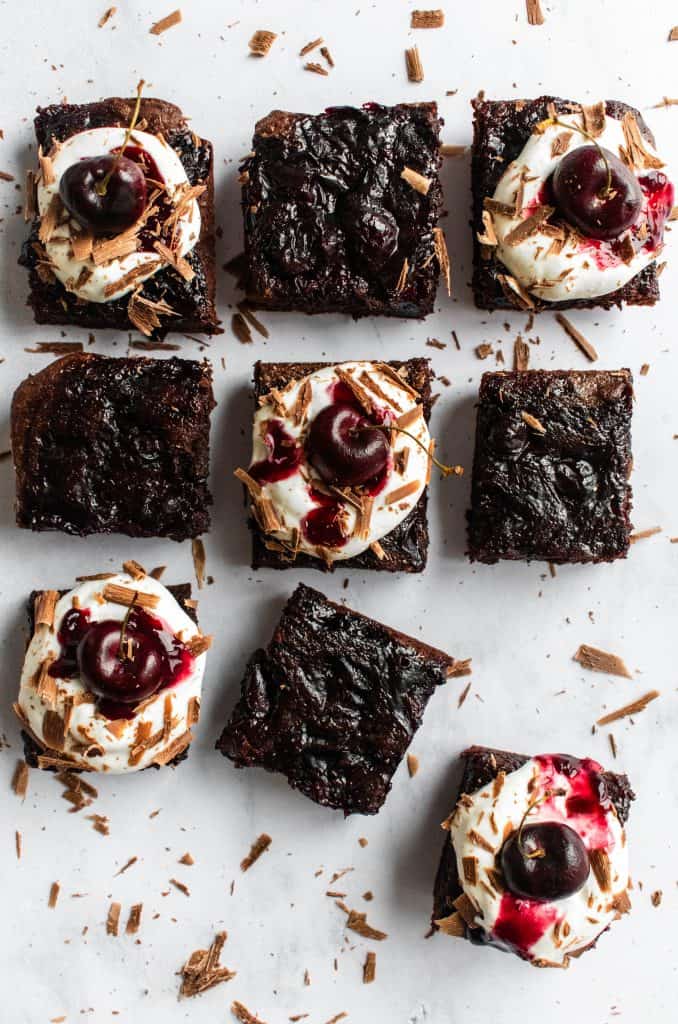 Nine Black Forest brownies laid out on a marble surface.