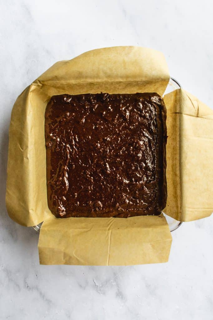 Raw brownie batter in a baking pan.