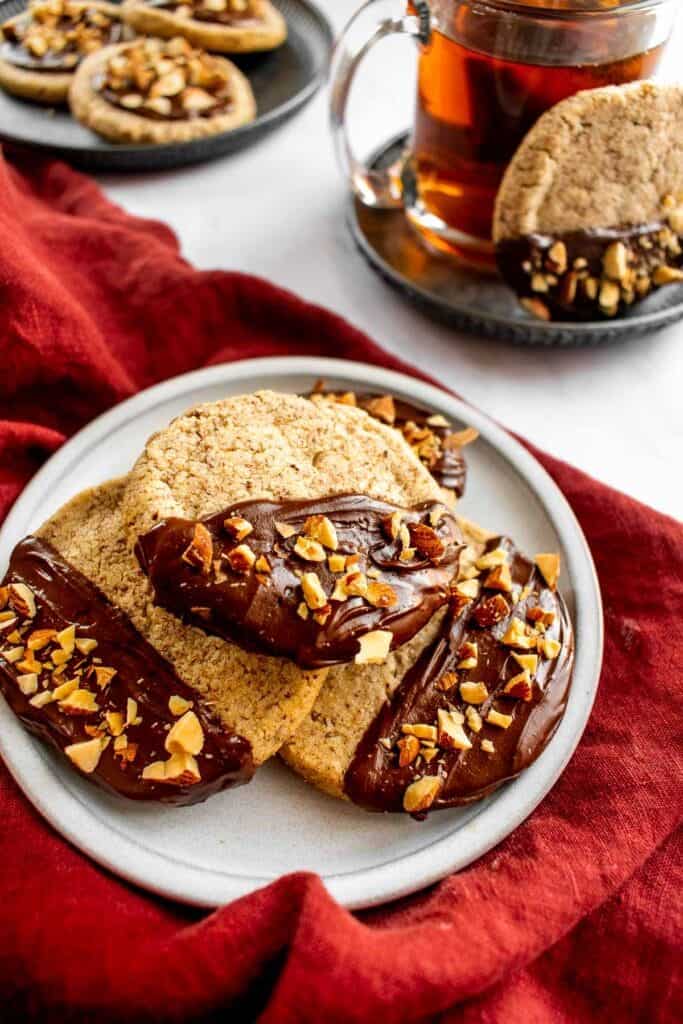 Three chocolate-dipped shortbread cookies on a plate.