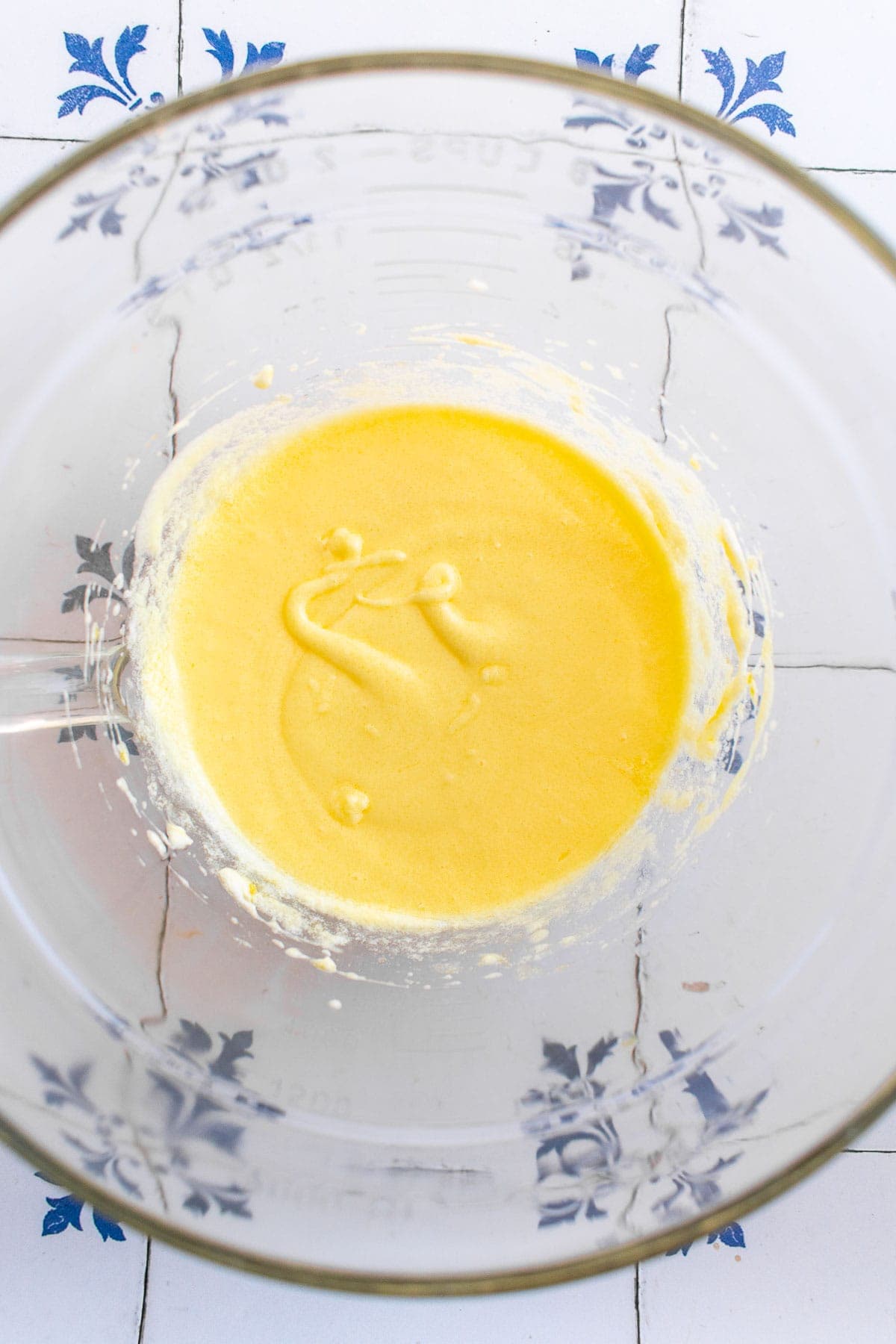 A yellow liquid mixture in a mixing bowl. 
