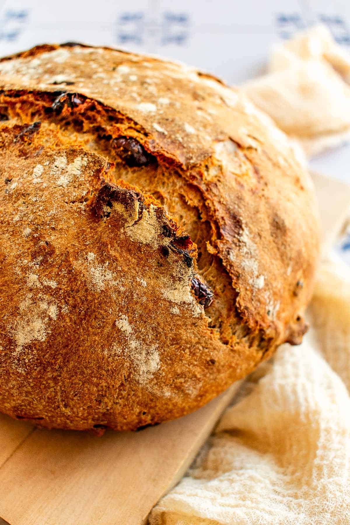 A loaf of bread with a crispy crust on a wooden board.