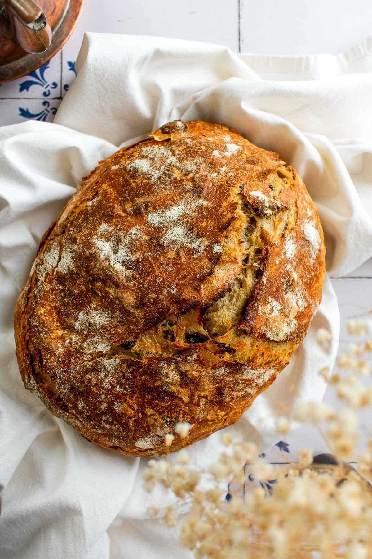 A baked loaf of bread on a white linen.