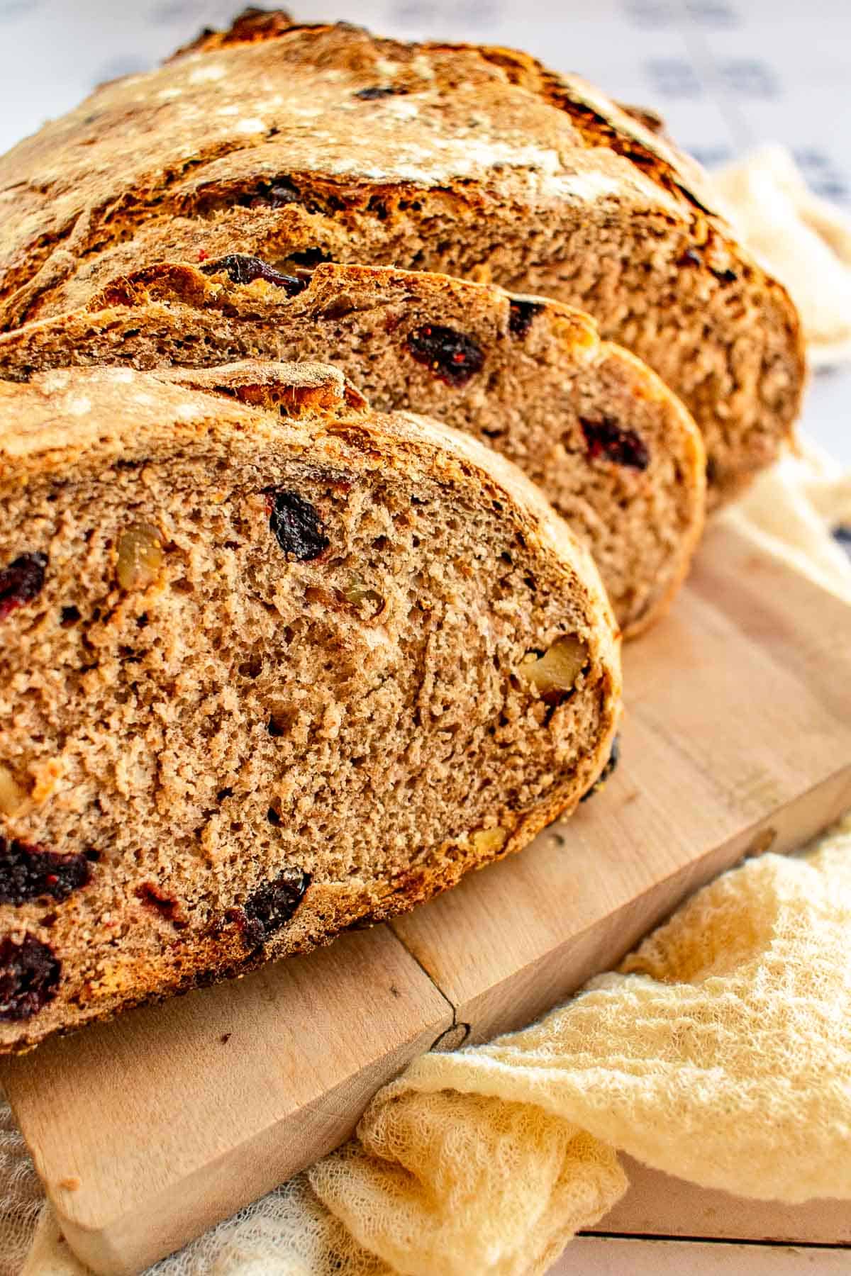 Slices of cranberry walnut bread on a cutting board.