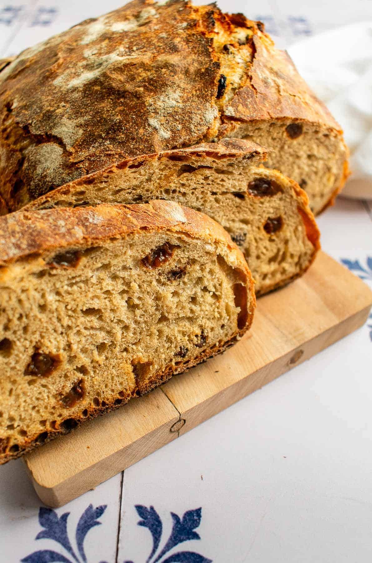 Two slices of raisin bread leaning against the rest of the loaf.