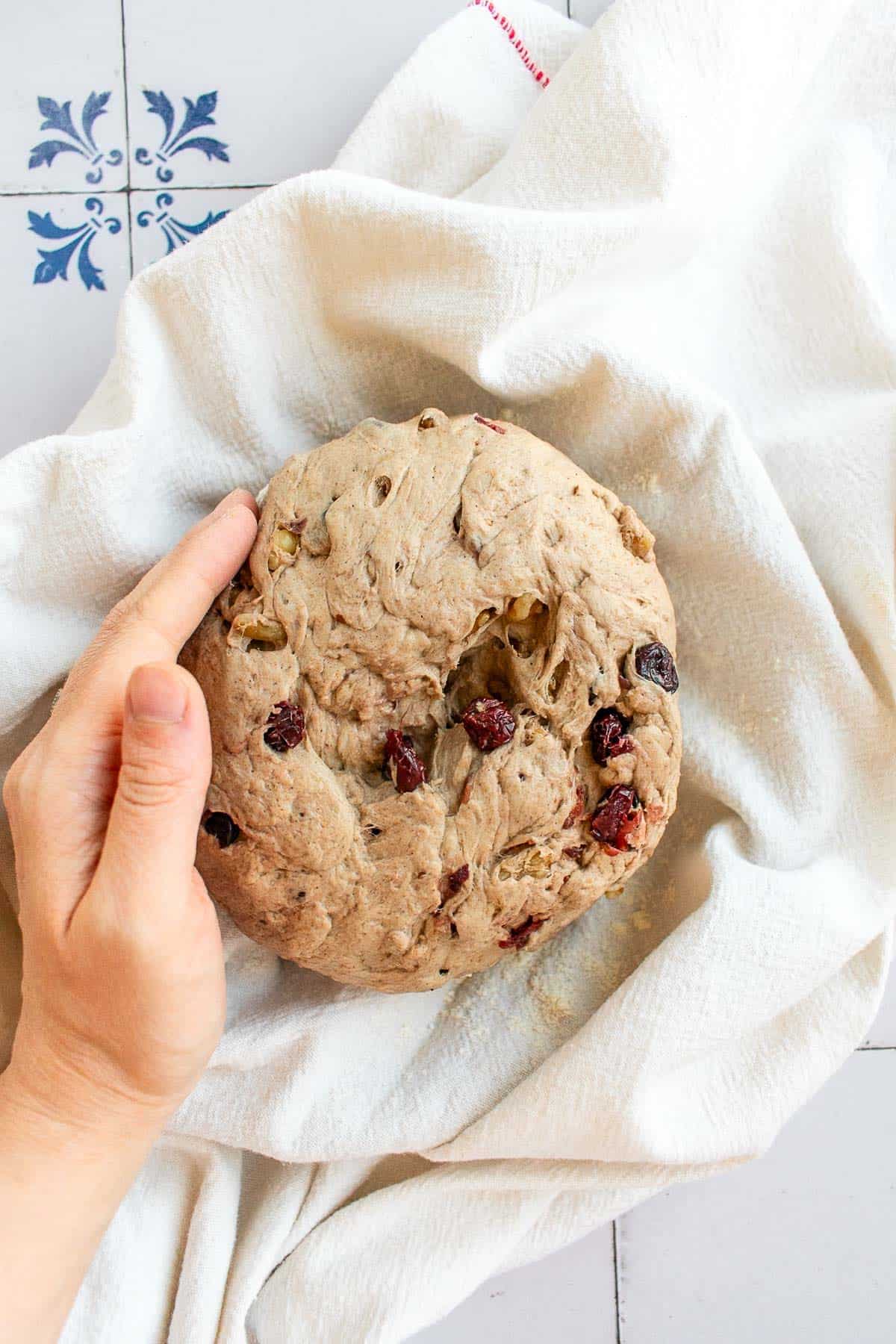 A ball of dough proofing in a towel-lined bowl. 