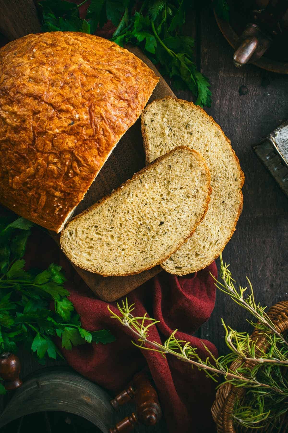 Two slices of bread on a board next to the rest of the artisan loaf.