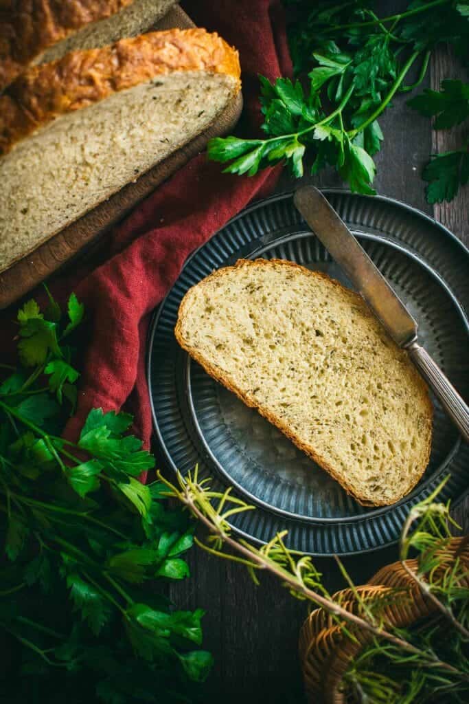 A slice of herb bread on a metal plate.