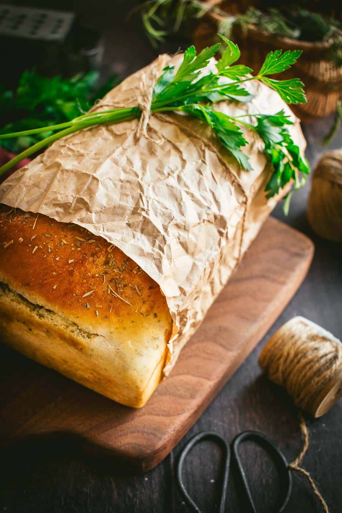 A loaf of bread wrapped in brown paper and twine.