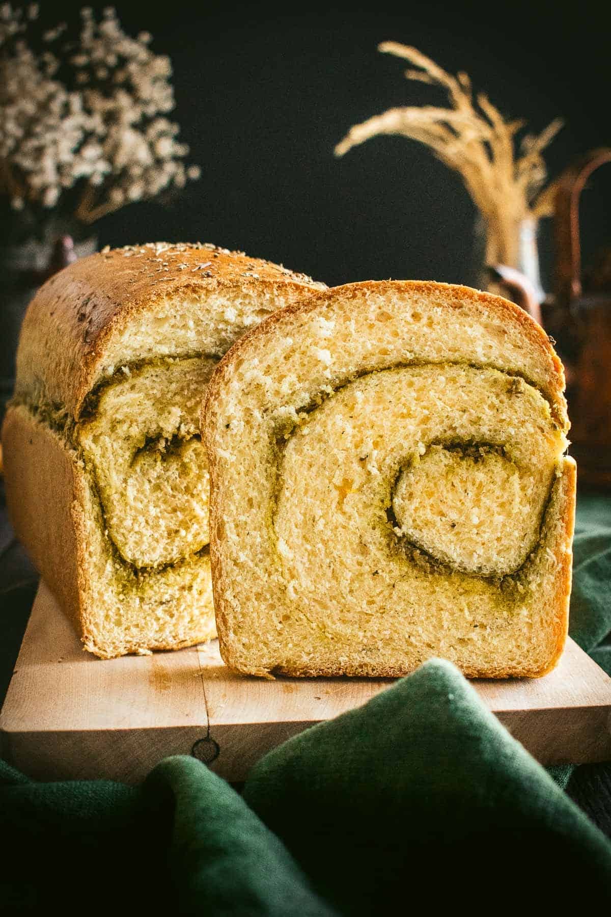 A sliced loaf of bread with a swirl of pesto inside.