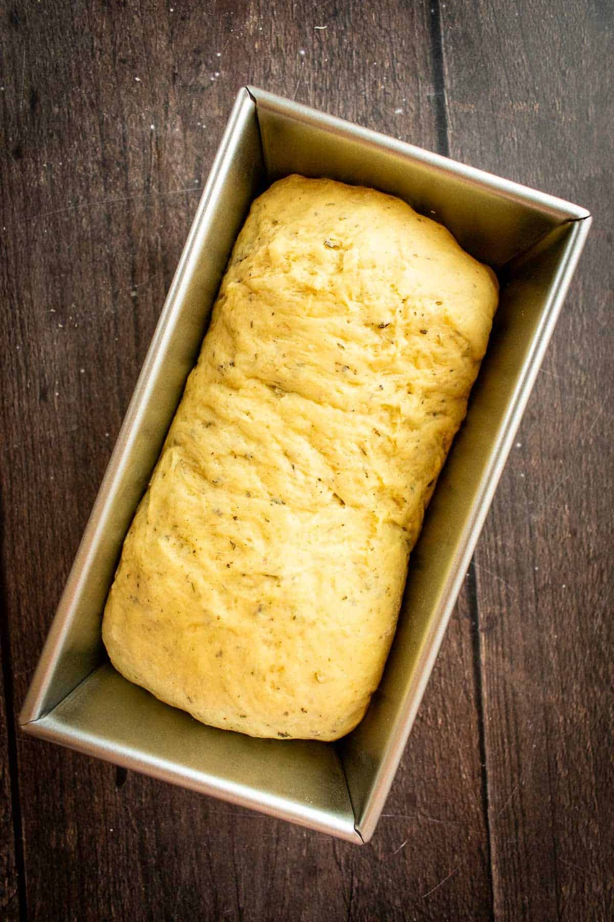 A loaf of unbaked bread in a metal loaf pan.