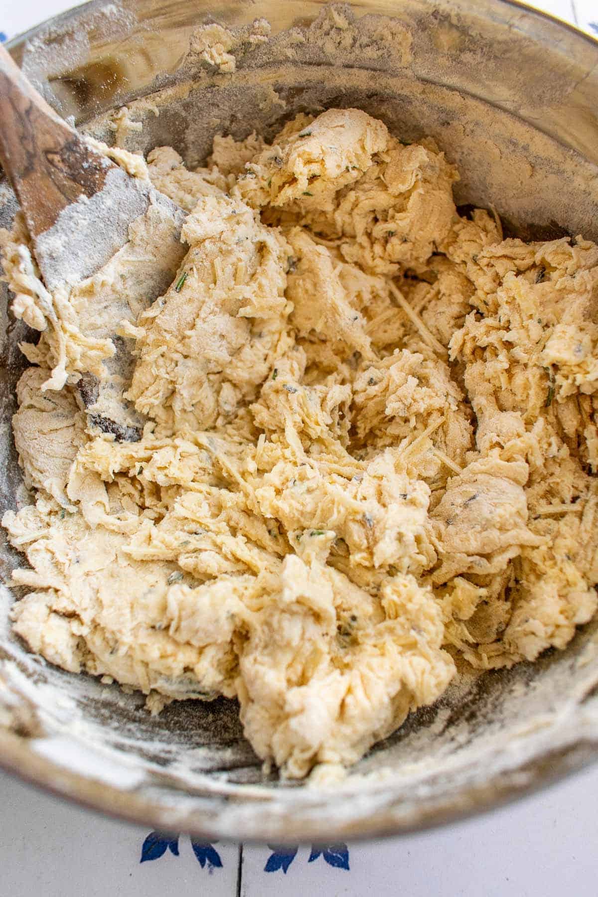 A shaggy bread dough in a metal mixing bowl.