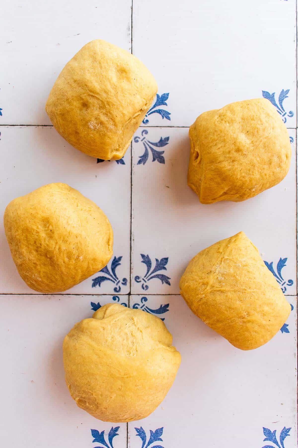 Five balls of bread dough on a table.