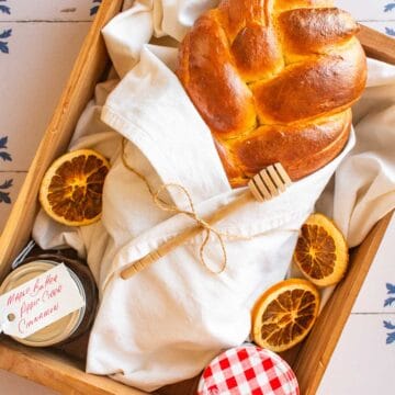 A loaf of braided bread wrapped in a linen in a wooden box.