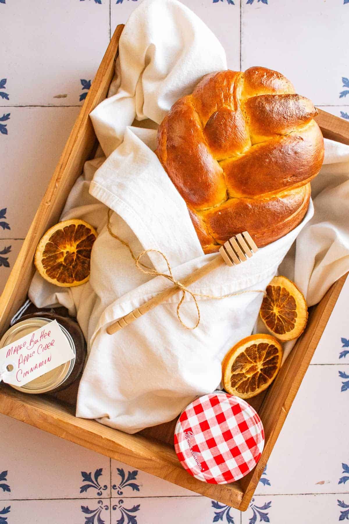 A loaf of braided bread wrapped in a linen in a wooden box.