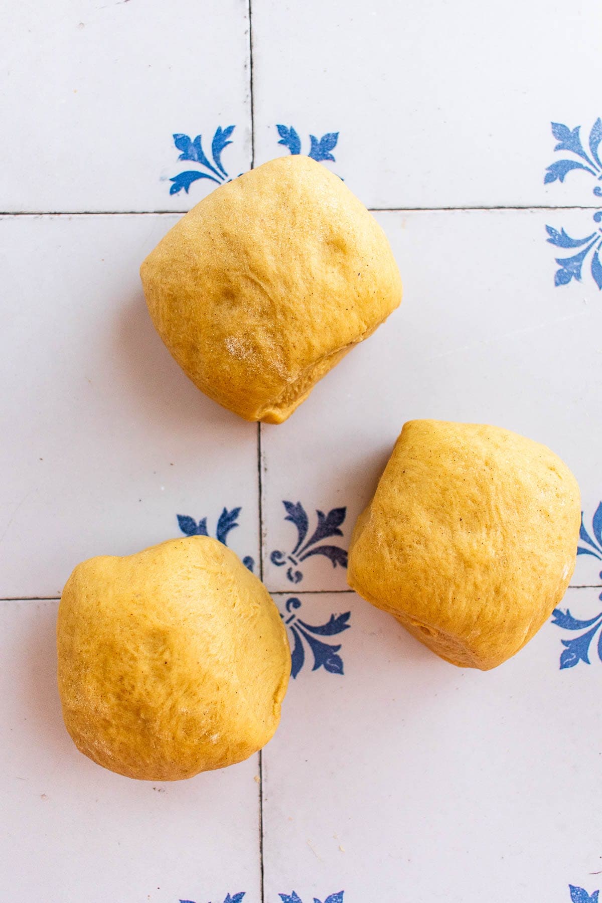 Three balls of bread dough on a table.