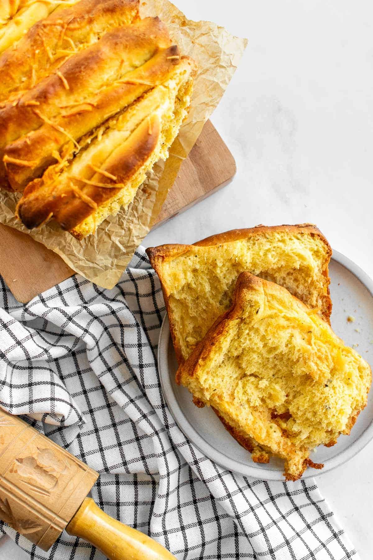 Two slices of cheese pull apart bread on a grey plate.