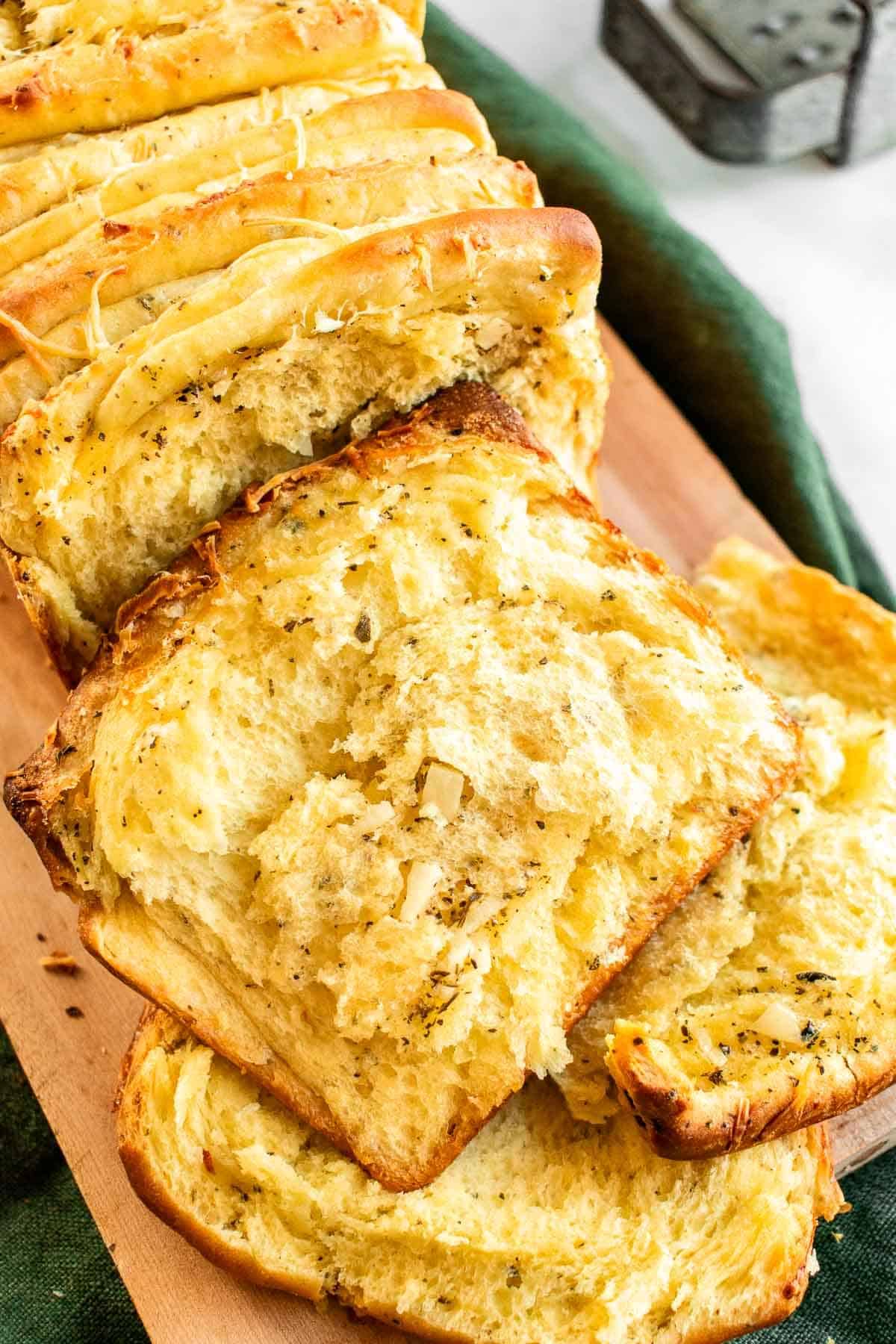 Slices of garlic bread on a wooden board.