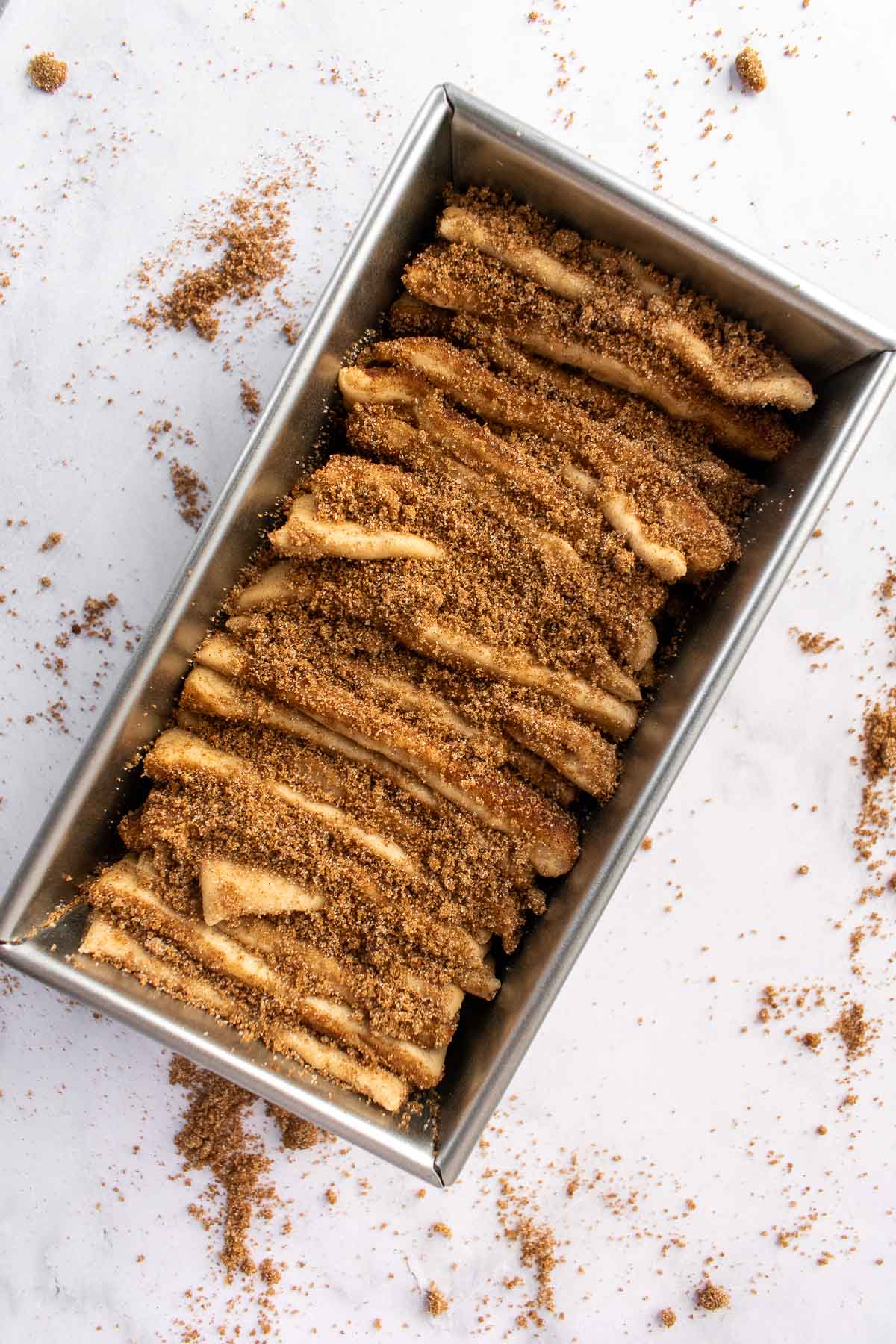 Unbaked cinnamon pull apart bread in a metal loaf pan.