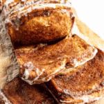Slices of glazed bread covered in melted butter, brown sugar, and cinnamon.
