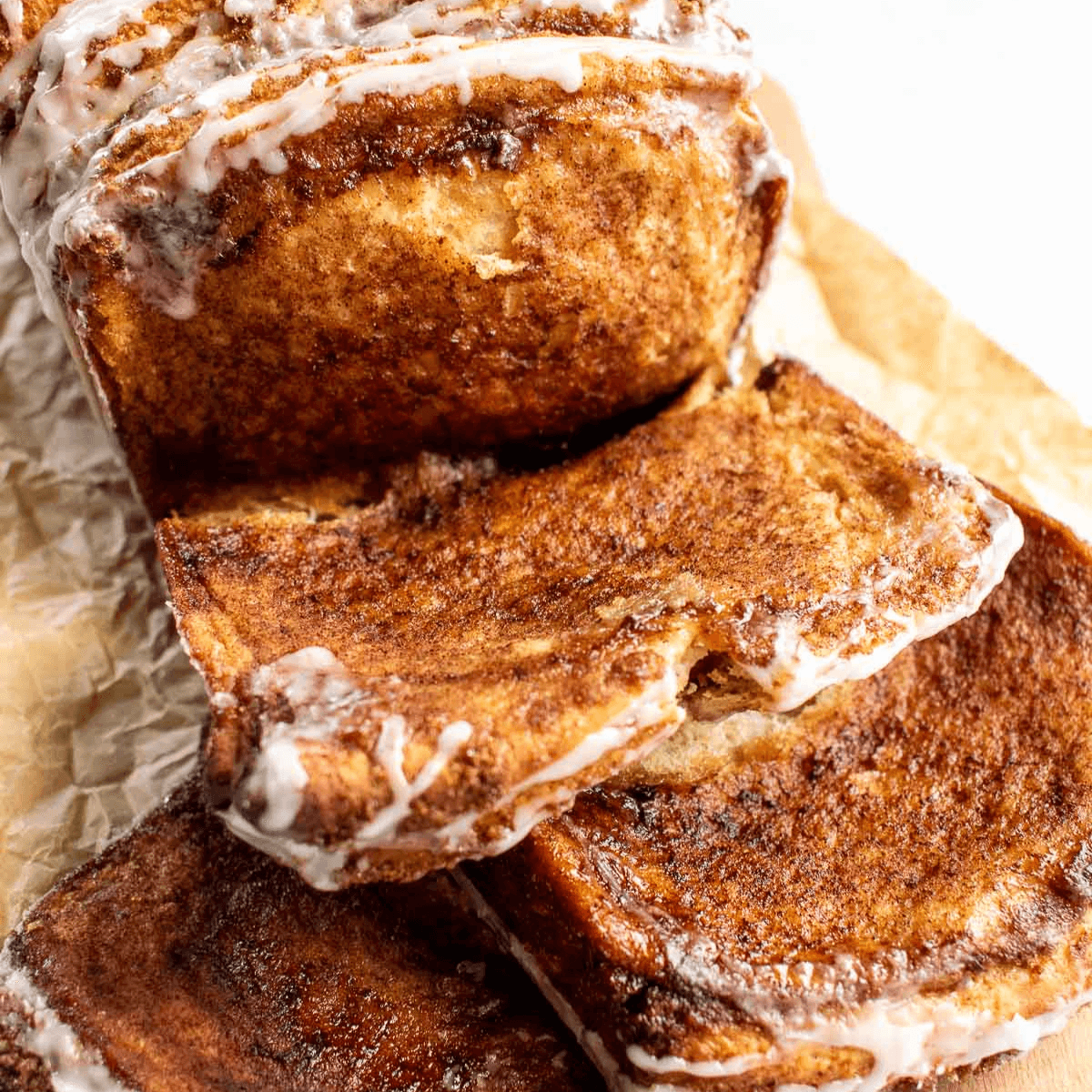 Slices of glazed bread covered in melted butter, brown sugar, and cinnamon.