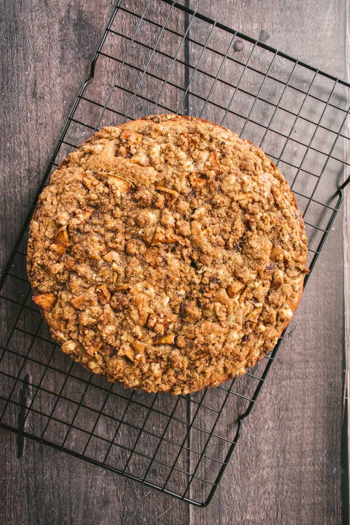 A baked apple fritter cake on a wire cooling rack.
