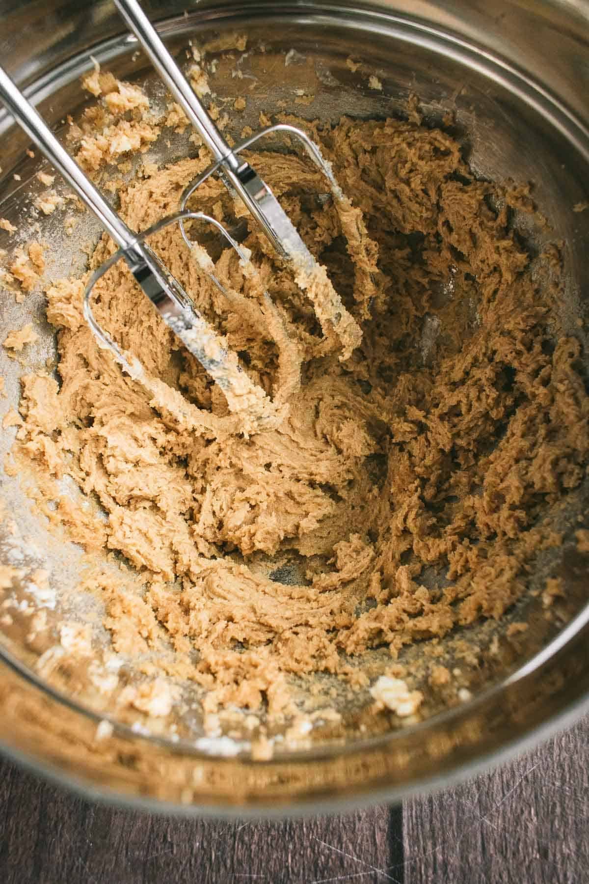 Butter and sugar beaten in a bowl with metal beaters.