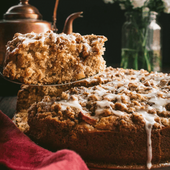 A slice of glazed coffee cake being lifted up by a metal cake server.