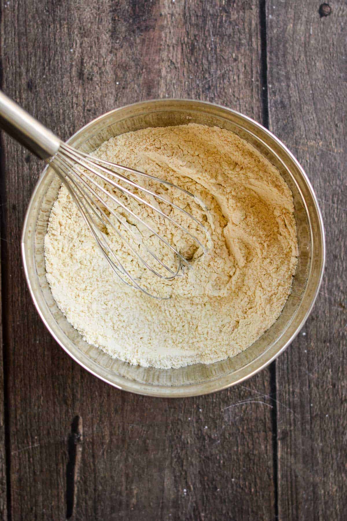 Flour, cinnamon, and salt whisked in a metal bowl.