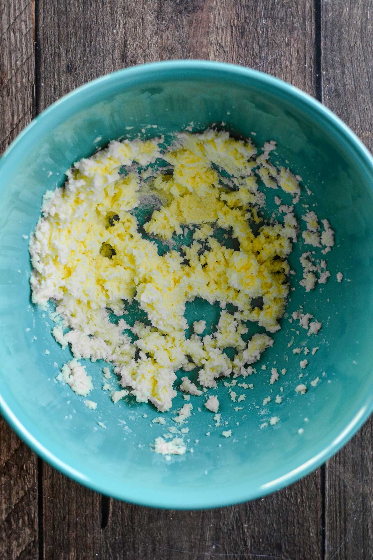 Butter and sugar beaten in a blue bowl.
