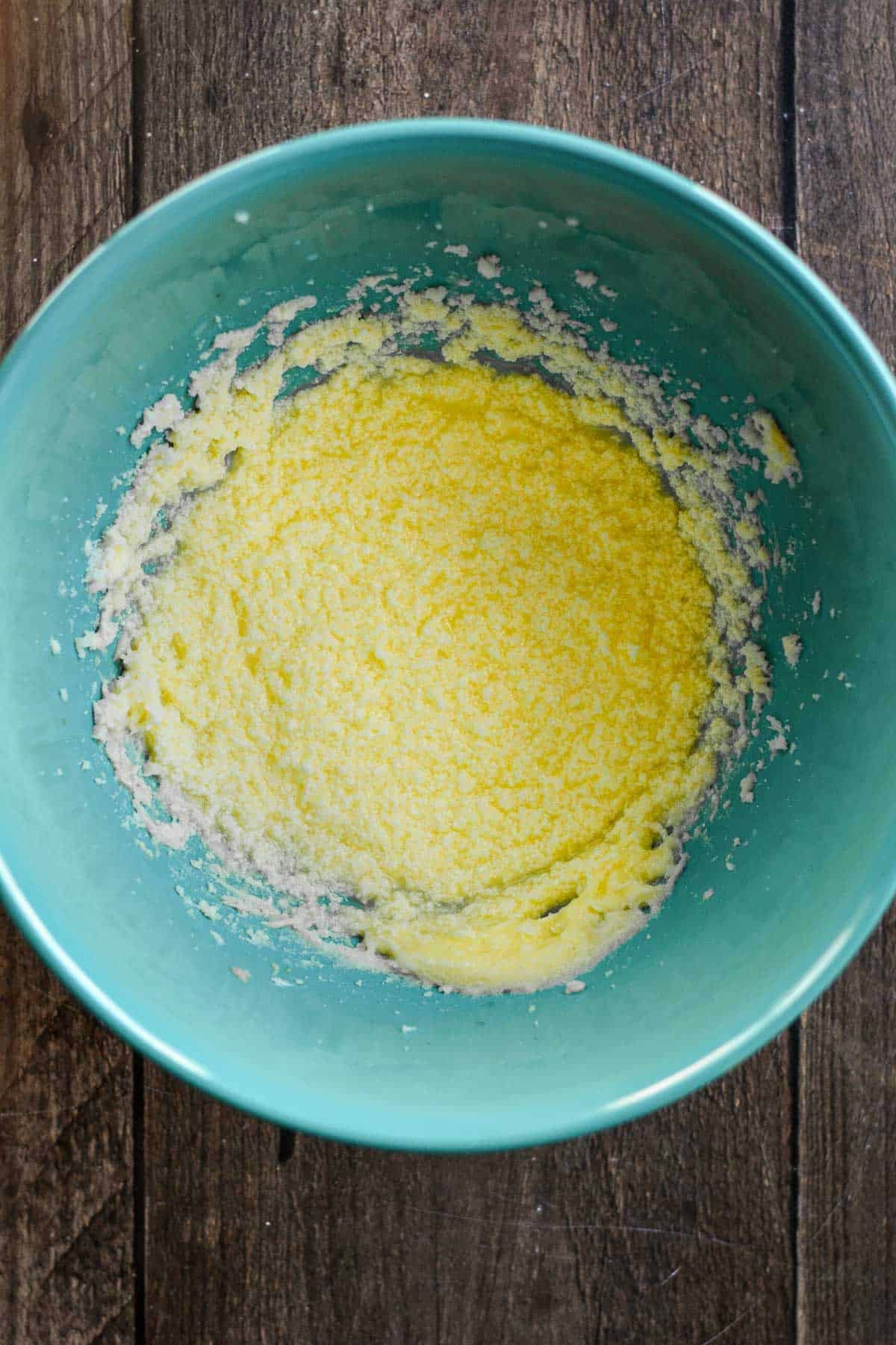 Butter, milk, sugar, eggs, and almond extract beaten in a bowl.
