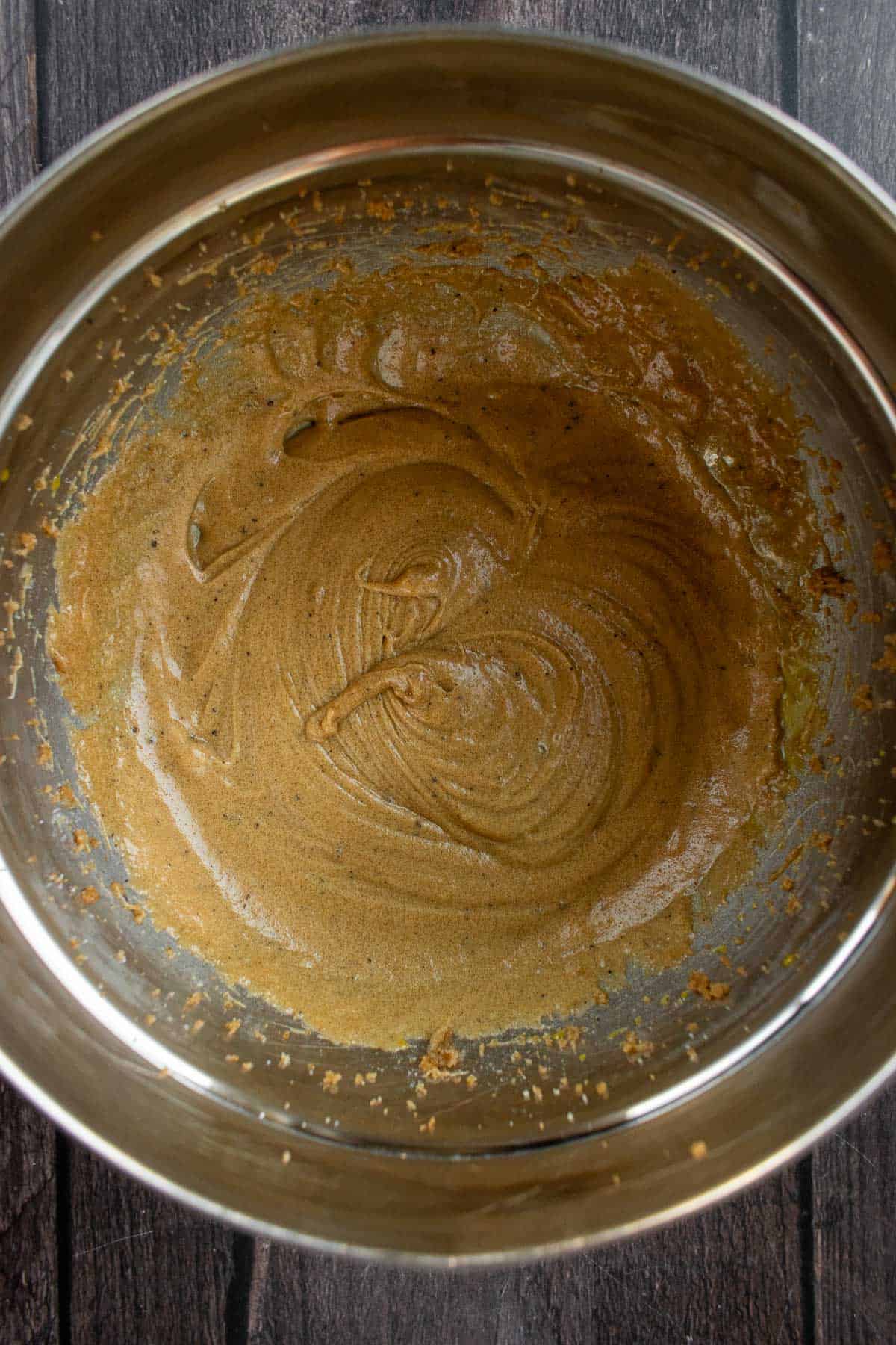 Butter, sugar, eggs, and vanilla mixed in a metal bowl.