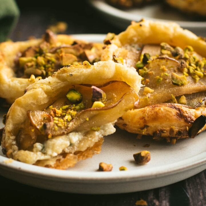 Three pear blue cheese tarts on a small plate.