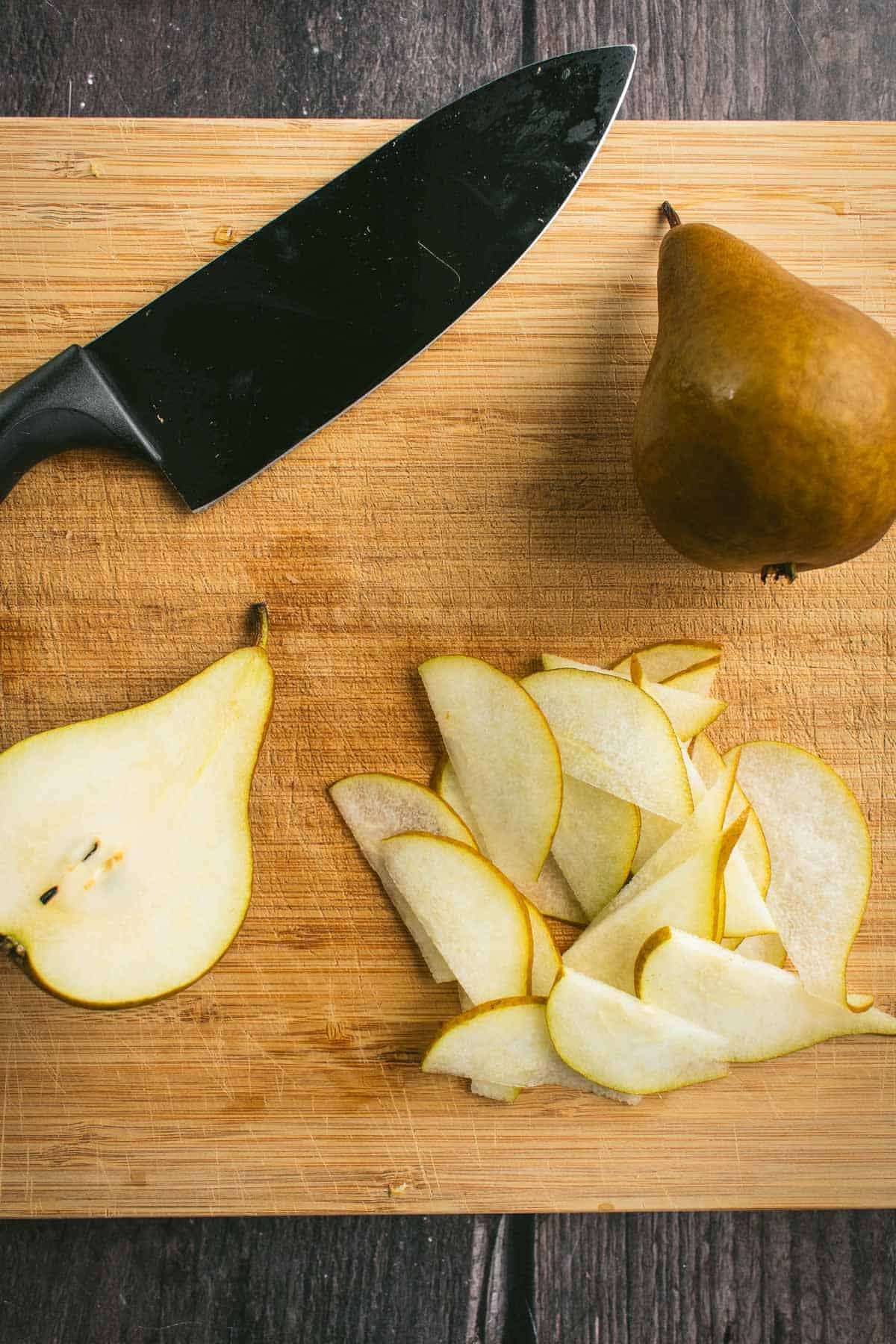 Thinly sliced pears on a cutting board.